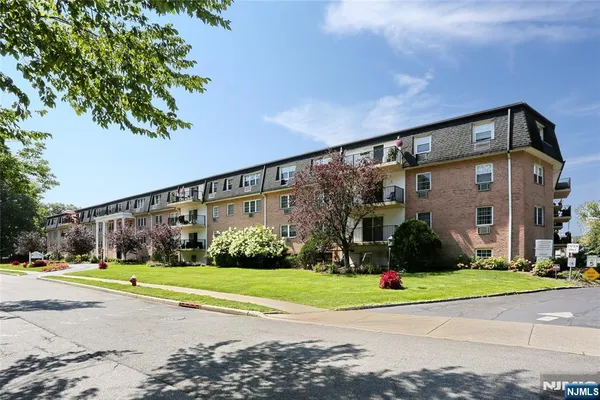 a view of a big house with a big yard and large trees