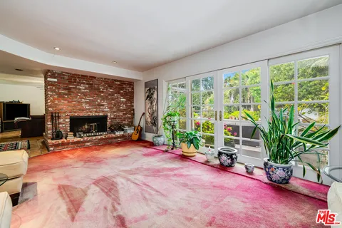 a living room with furniture a flat screen tv and a large window