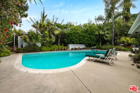 a view of a chairs and table in a back yard of the house