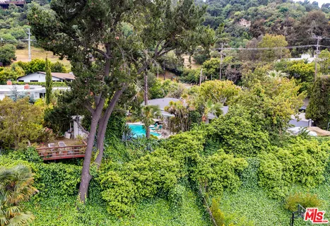 an aerial view of a house with a yard and swimming pool