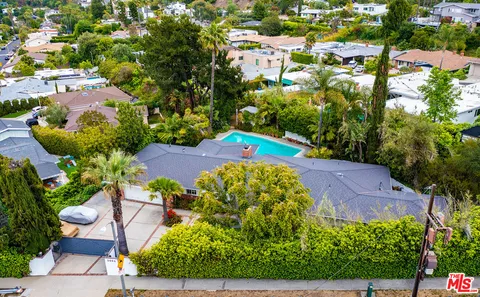 a view of a swimming pool with lawn chairs and a fire pit