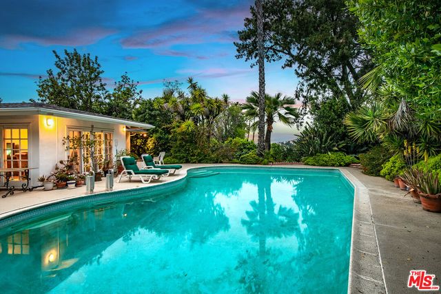 a front view of a house with swimming pool garden and patio