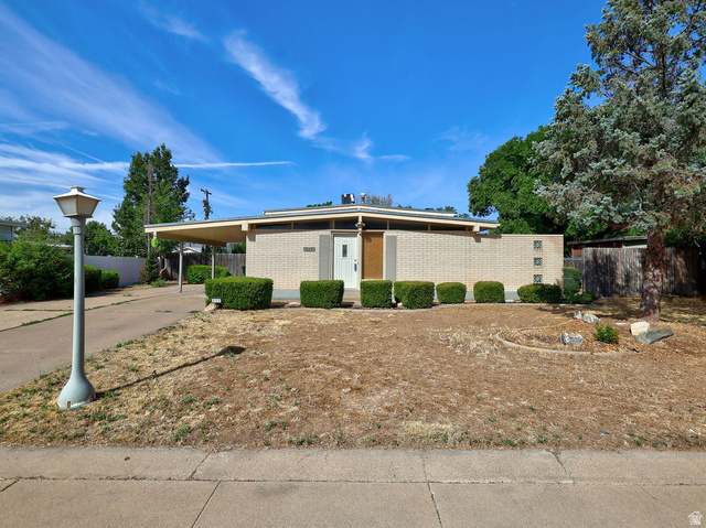 669 Colonial Avenue Layton, UT 84041 - Photo 1 of 51 Mid-century modern residence featuring a light-colored brick exterior, a flat roofline, and an attached carport
