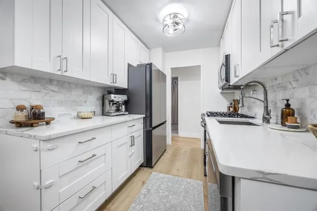 a kitchen with a sink stainless steel appliances and cabinets