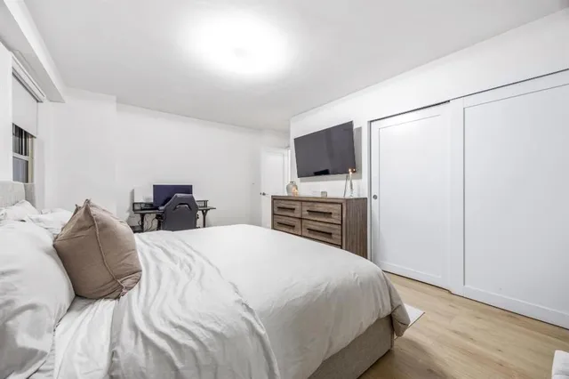 a bedroom with a bed and a flat screen tv