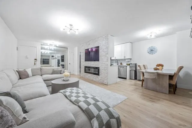 a living room with furniture a fireplace and a open kitchen view