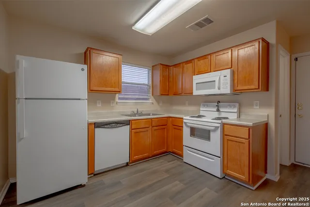 a kitchen with stainless steel appliances granite countertop a refrigerator sink and stove