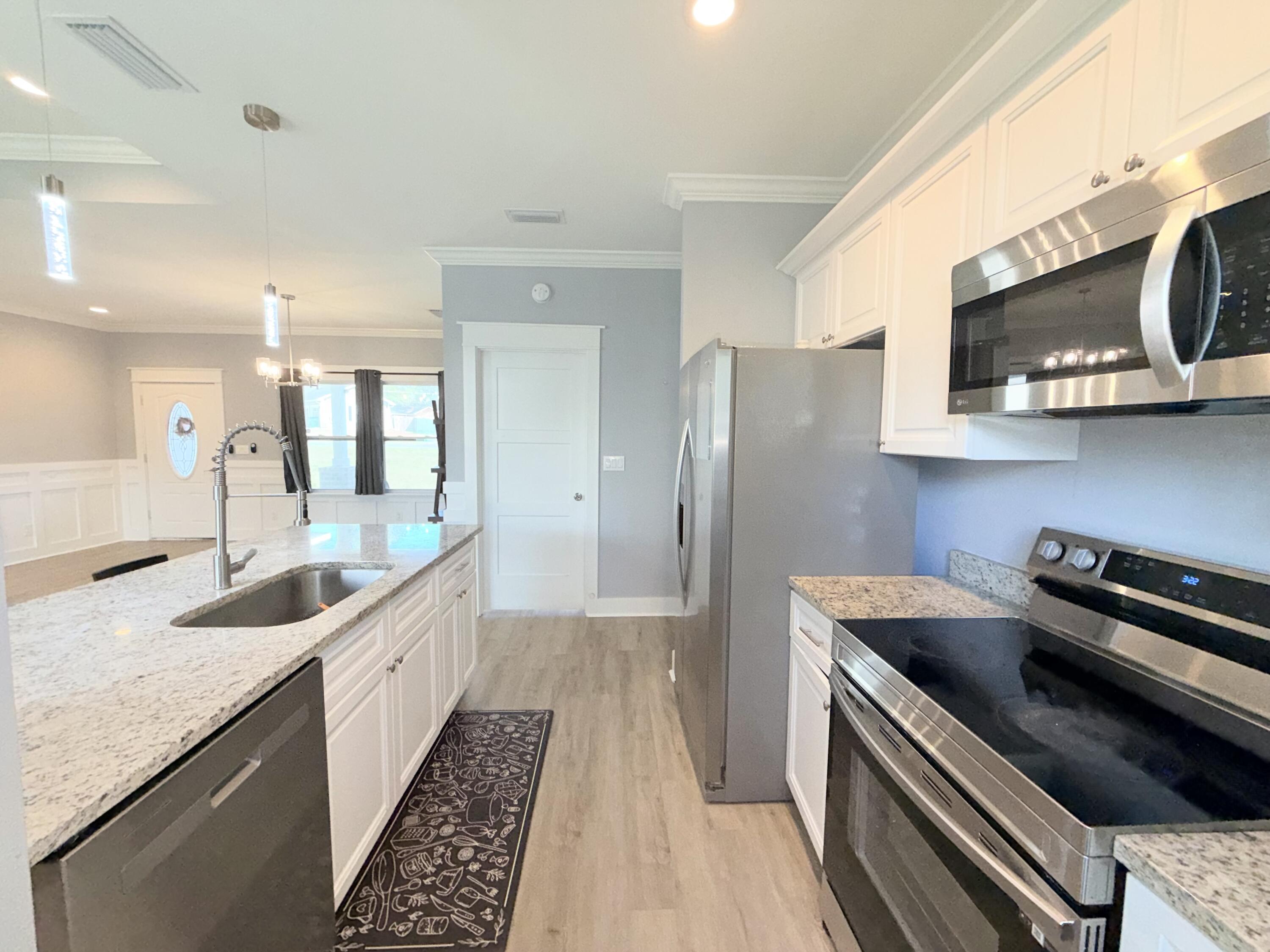122 Loblolly Circle Midway, FL 32343 - Photo 15 of 38 a kitchen with stainless steel appliances granite countertop a sink stove and refrigerator
