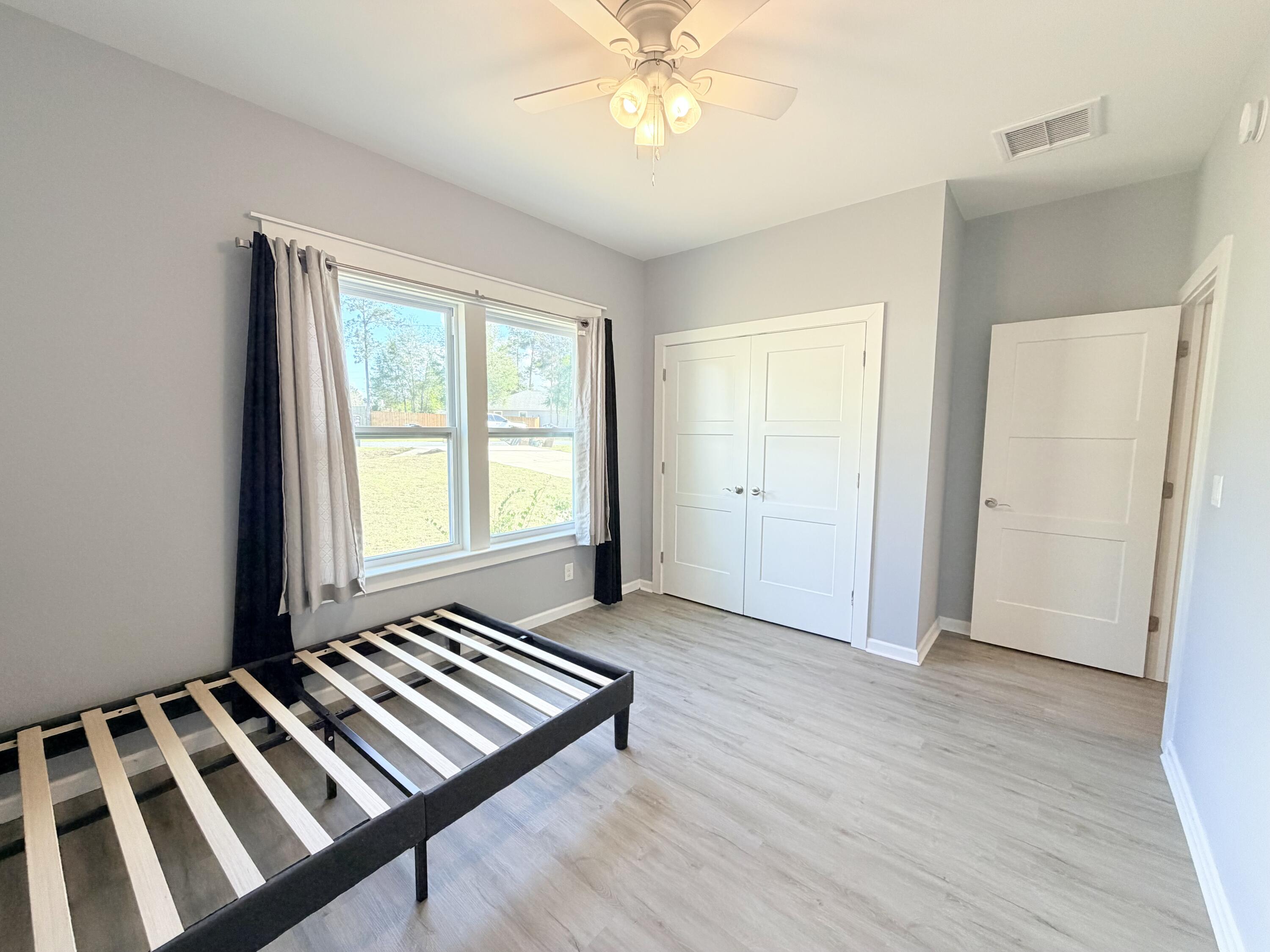 122 Loblolly Circle Midway, FL 32343 - Photo 27 of 38 a view of a room with wooden floor windows and a ceiling fan