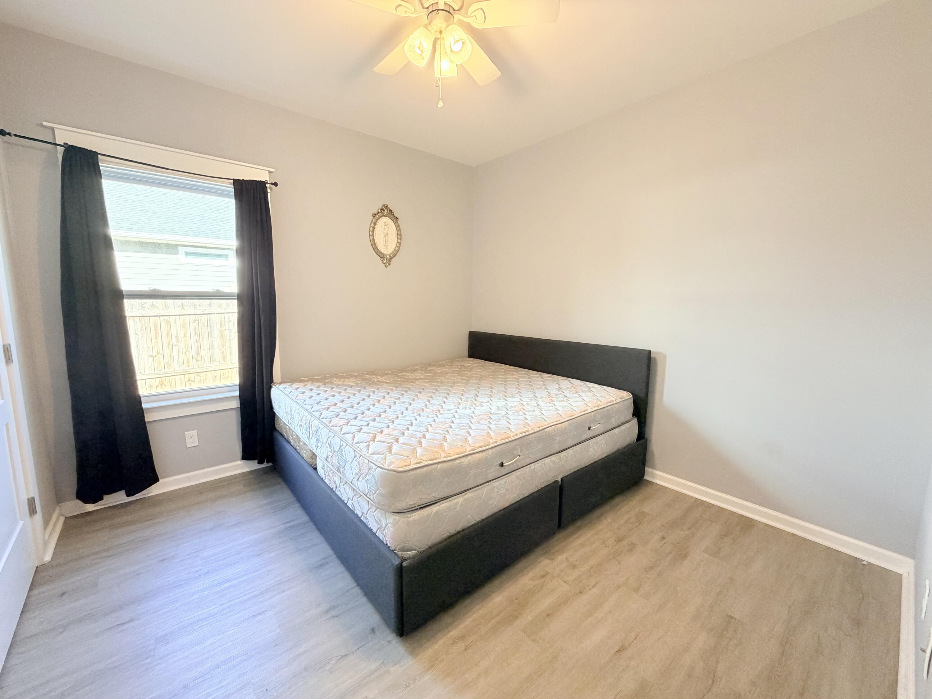 122 Loblolly Circle Midway, FL 32343 - Photo 28 of 38 a large bed sitting in a bedroom next to a window and a chandelier