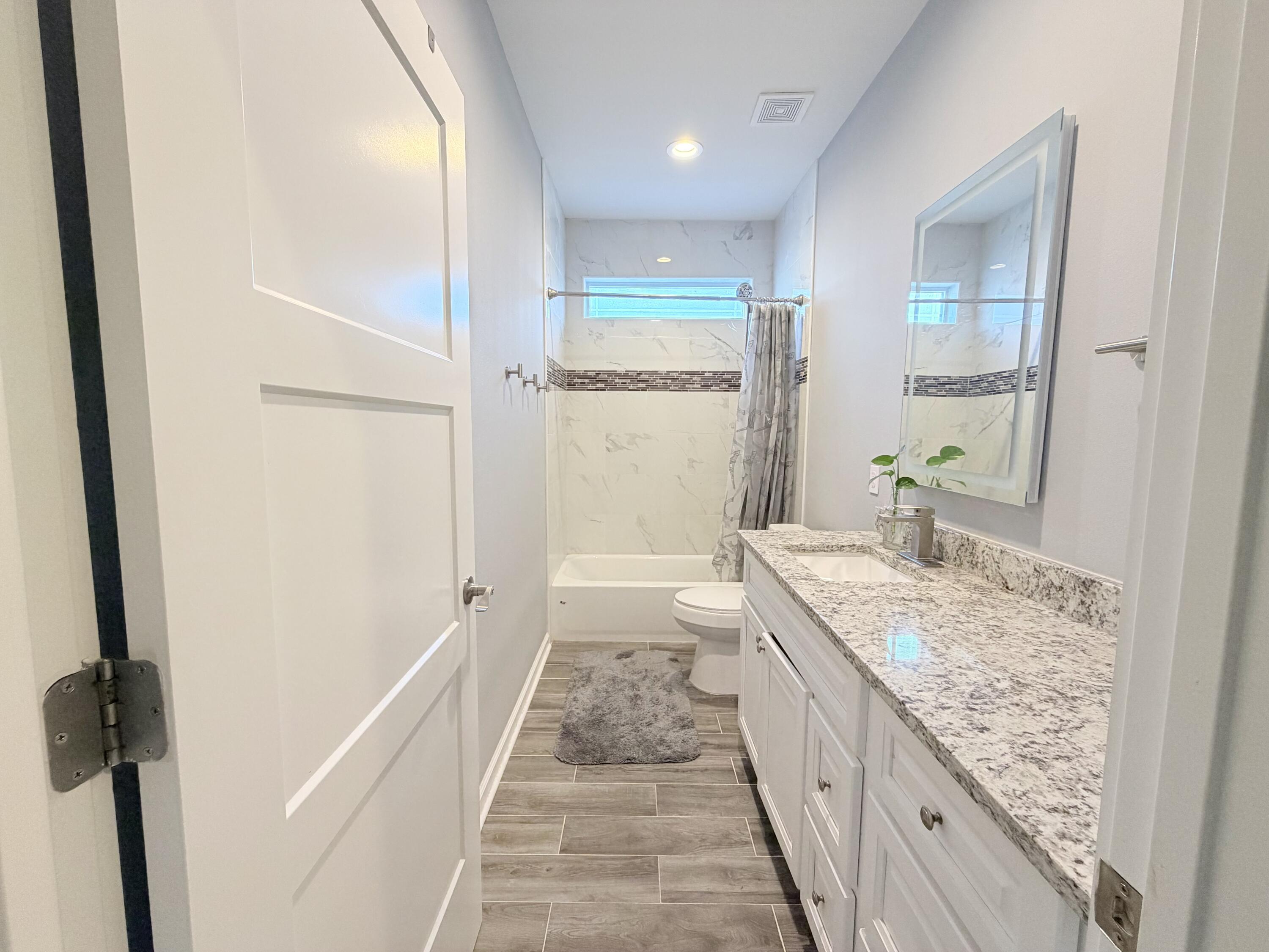 122 Loblolly Circle Midway, FL 32343 - Photo 33 of 38 a bathroom with a granite countertop sink a toilet and a shower