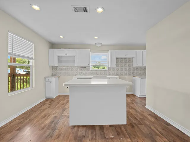 a kitchen with a sink cabinets and wooden floor