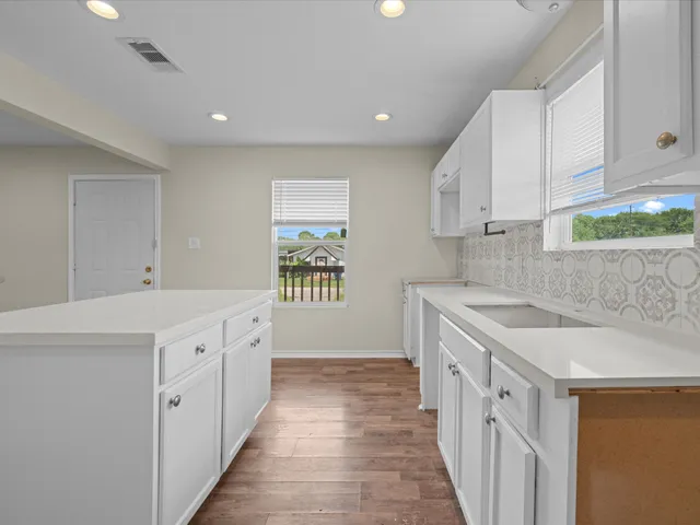 a kitchen with stainless steel appliances granite countertop a sink and dishwasher with white cabinets