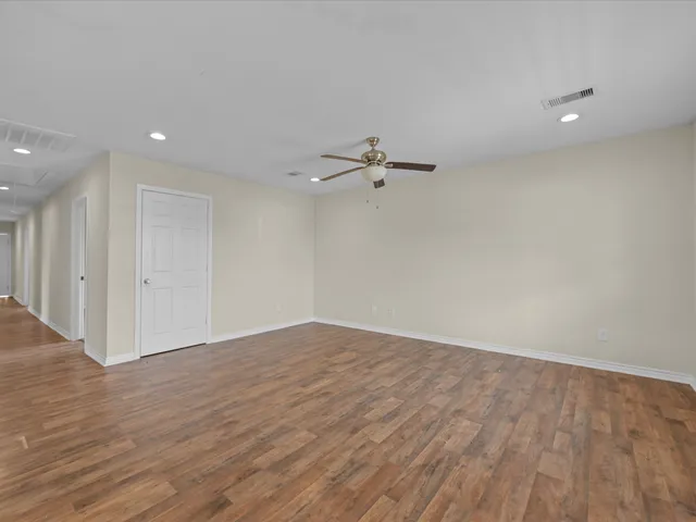 a view of an empty room with wooden floor