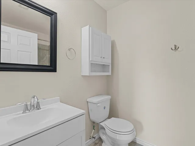 a bathroom with a toilet a sink and mirror