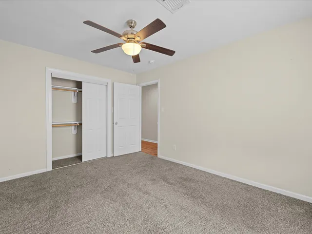 an empty room with closet and fan