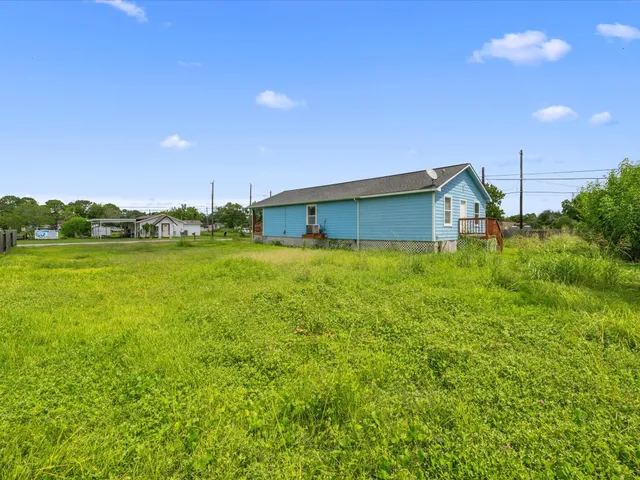 a backyard of a house with lots of green space and lake view