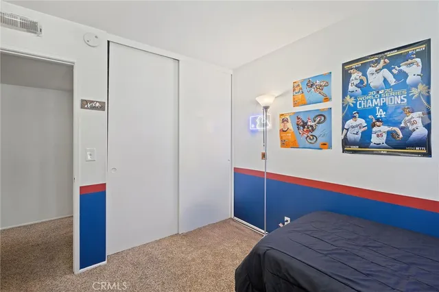 a bedroom with a bed and painting on the wall