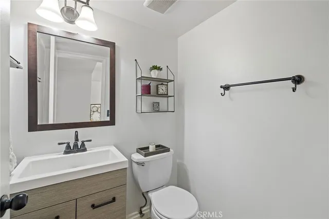 a bathroom with a sink vanity mirror and toilet