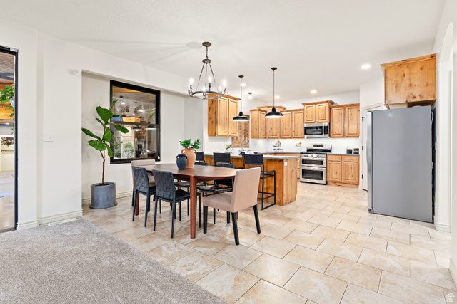 912 North Loafer Canyon Road Elk Ridge, UT 84651 - Photo 14 of 98 Spacious kitchen and dining area featuring natural wood cabinetry, stainless steel appliances, and a central island with pendant lighting