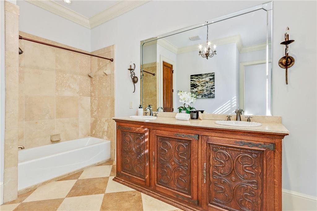 4227 Peachtree Dunwoody Road Atlanta, GA 30342 - Photo 14 of 44 a bathroom with a granite countertop sink a mirror a bathtub and shower