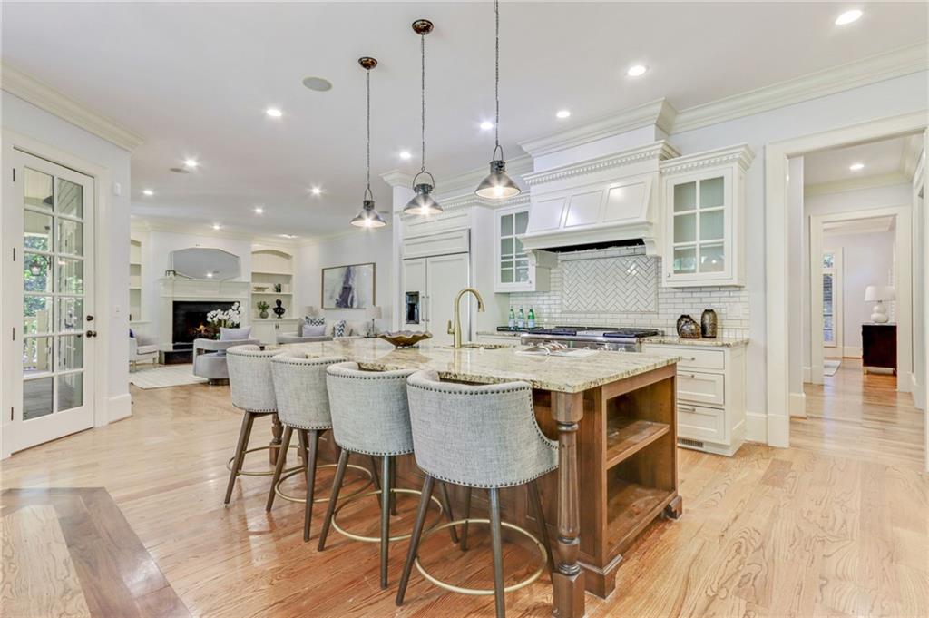 4227 Peachtree Dunwoody Road Atlanta, GA 30342 - Photo 18 of 44 a kitchen with a dining table wooden floor and a view of kitchen