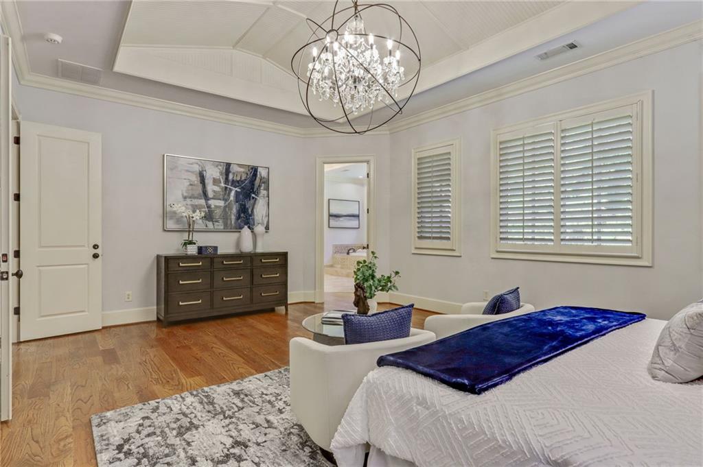 4227 Peachtree Dunwoody Road Atlanta, GA 30342 - Photo 26 of 44 a bedroom with a bed and a chandelier