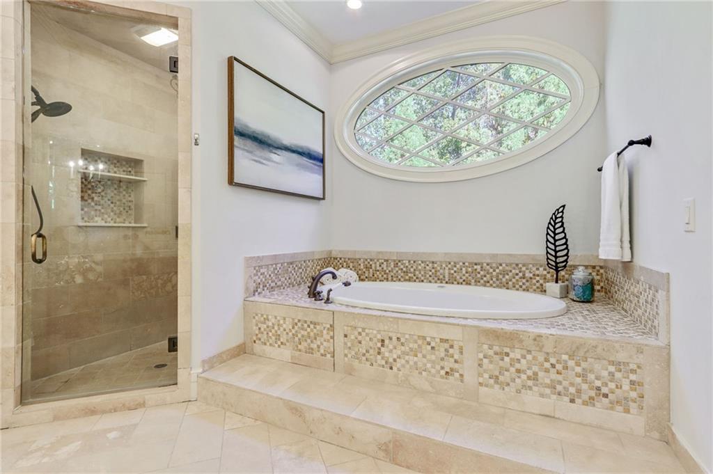 4227 Peachtree Dunwoody Road Atlanta, GA 30342 - Photo 28 of 44 a bathroom with a bathtub and a shower