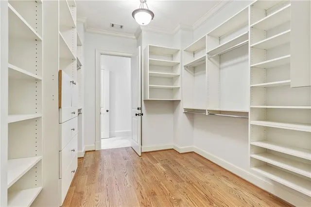 a view of walk in closet with empty racks