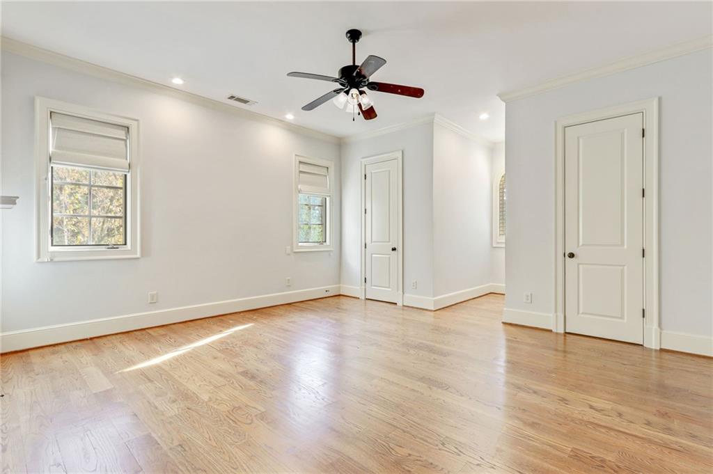 4227 Peachtree Dunwoody Road Atlanta, GA 30342 - Photo 32 of 44 a view of an empty room with wooden floor and a ceiling fan