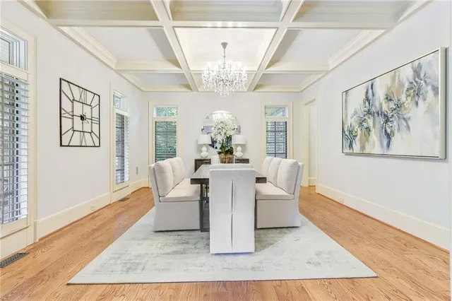 a view of a dining room with furniture a chandelier and wooden floor