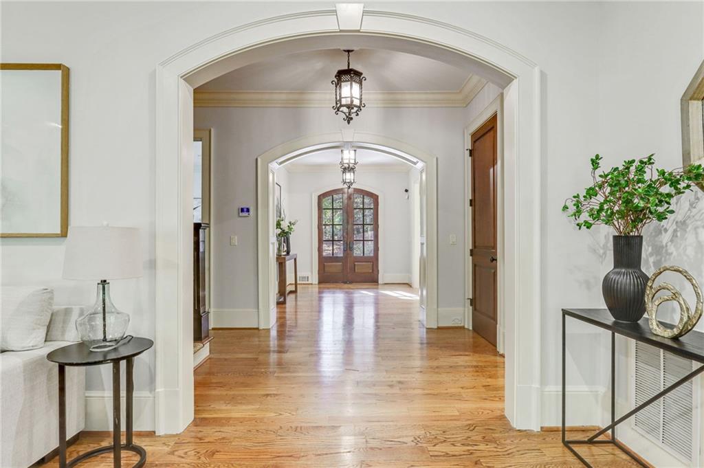 4227 Peachtree Dunwoody Road Atlanta, GA 30342 - Photo 8 of 44 a view of a hallway with wooden floor windows and a chandelier