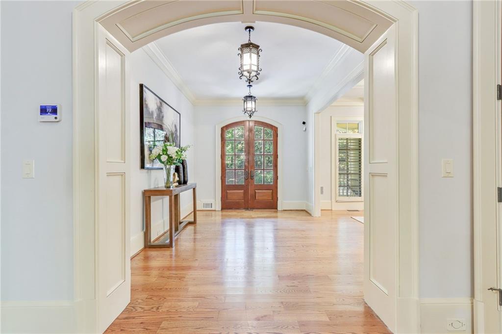 4227 Peachtree Dunwoody Road Atlanta, GA 30342 - Photo 9 of 44 a hallway with wooden floor chandelier and entryway