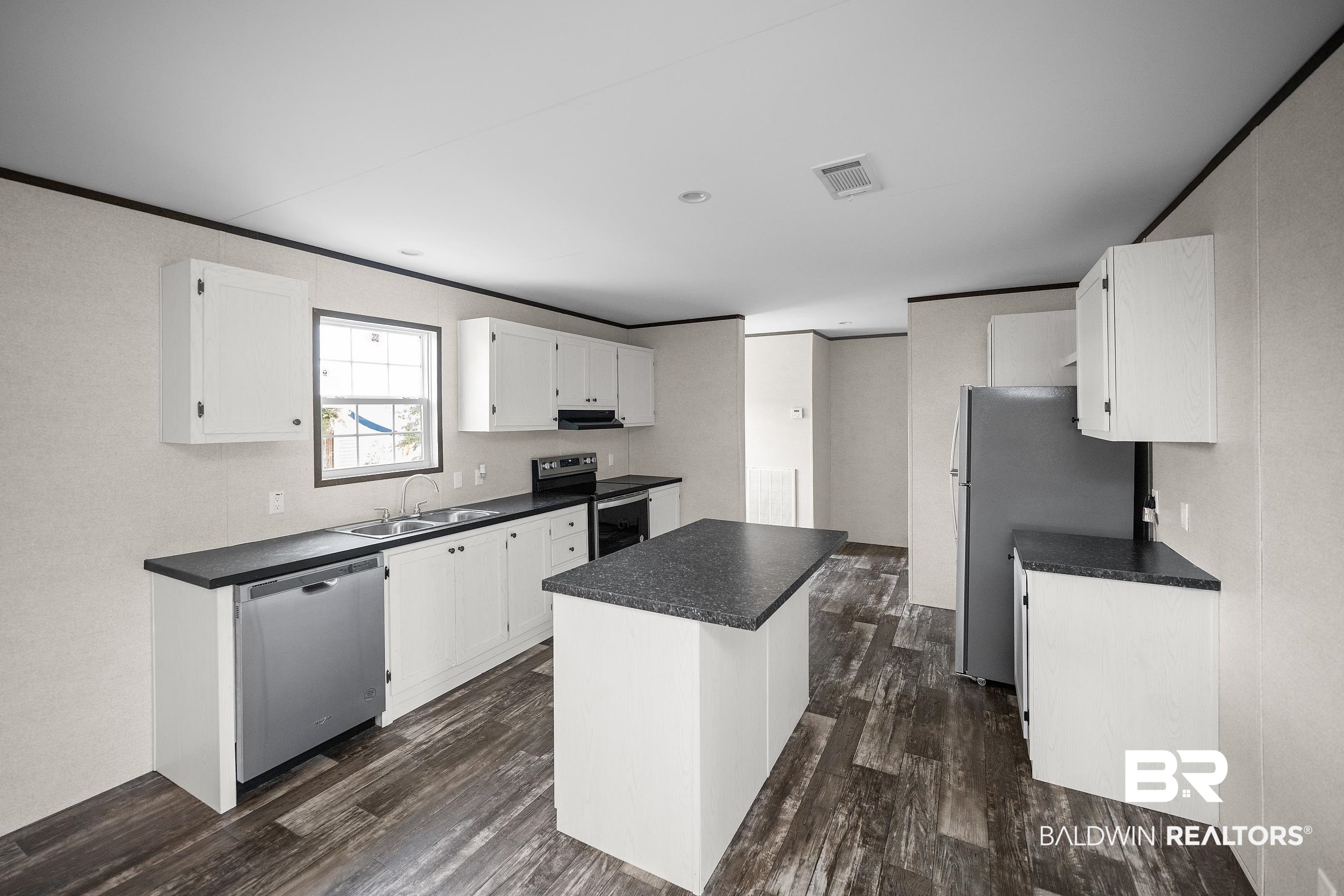 21601 Westside Loop Silverhill, AL 36576 - Photo 15 of 42 Kitchen featuring an island, white cabinetry, dark countertops, a stainless steel dishwasher, and wood-finish flooring
