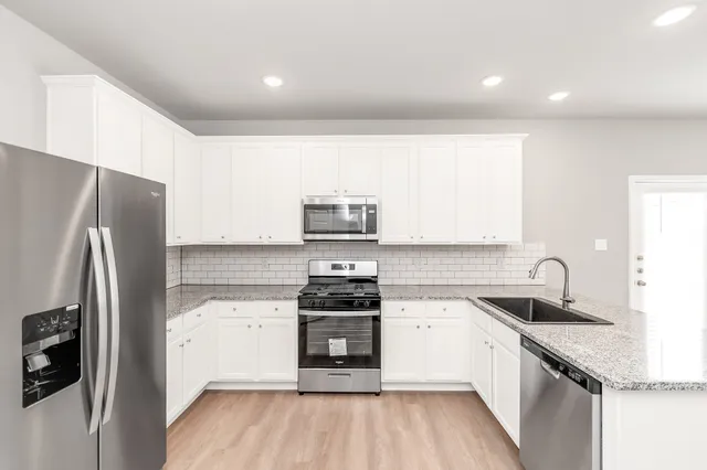 a kitchen with granite countertop stainless steel appliances cabinets a sink and a counter space