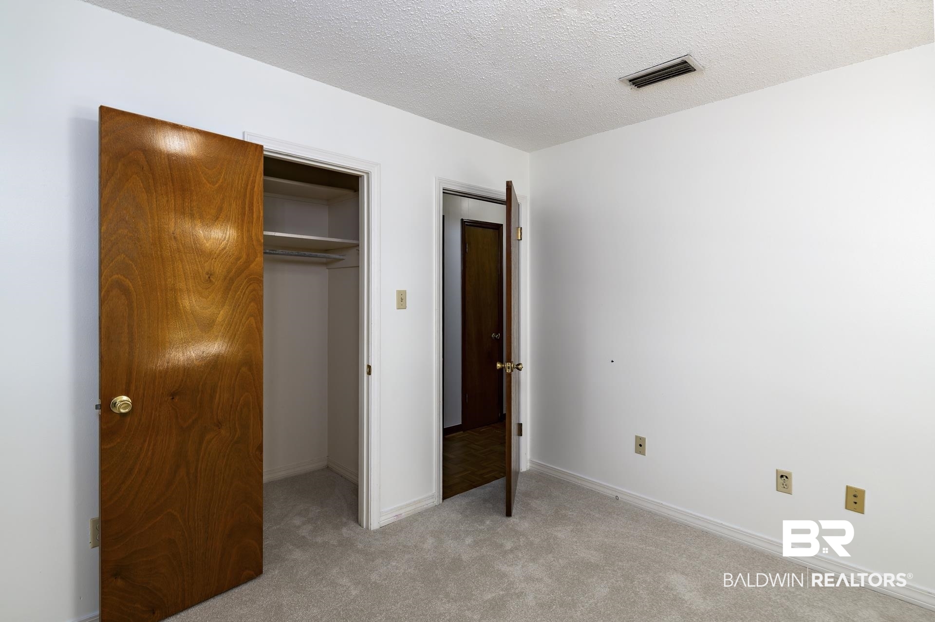 707 Johnson Avenue Fairhope, AL 36532 - Photo 31 of 38 Unfurnished bedroom with a textured ceiling, a closet, light colored carpet, visible vents, and baseboards