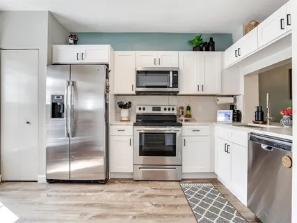 a kitchen with cabinets stainless steel appliances and a counter space