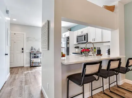 a kitchen with stainless steel appliances kitchen island granite countertop a refrigerator and microwave