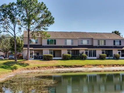 a view of a building with a big yard and large trees