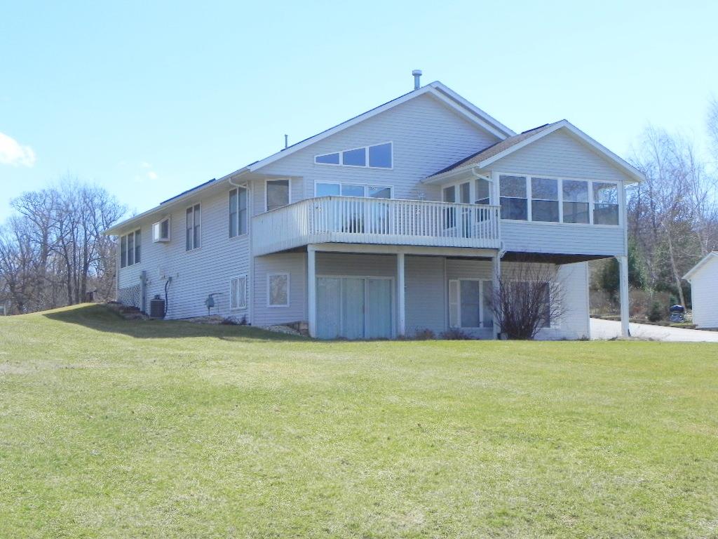 a view of a house with a yard and a large tree