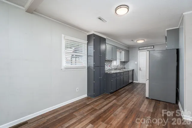 a kitchen with stainless steel appliances a refrigerator and a wooden floor