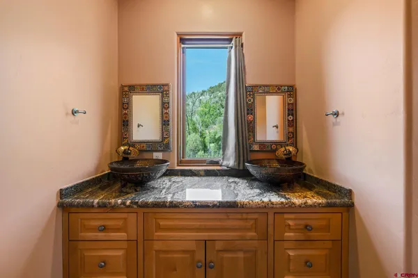 a bathroom with a granite countertop sink and a mirror