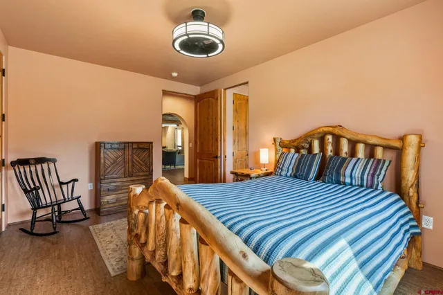 a bedroom with a bed a couch and a chandelier