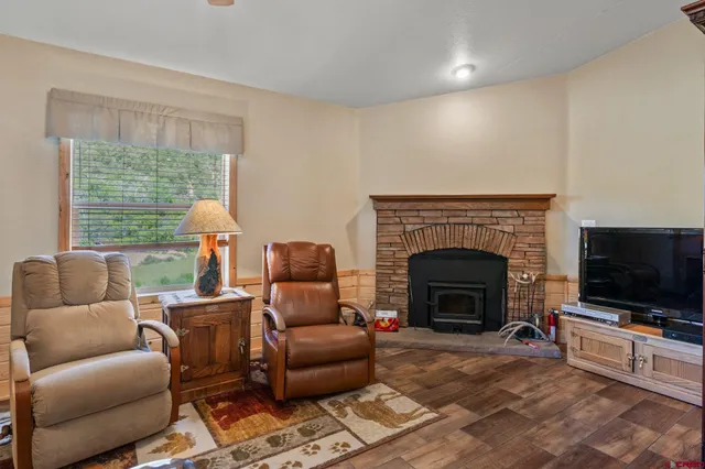 a living room with furniture a flat screen tv and a fireplace