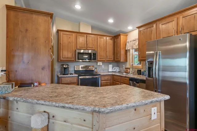 a kitchen with stainless steel appliances granite countertop a sink refrigerator and microwave