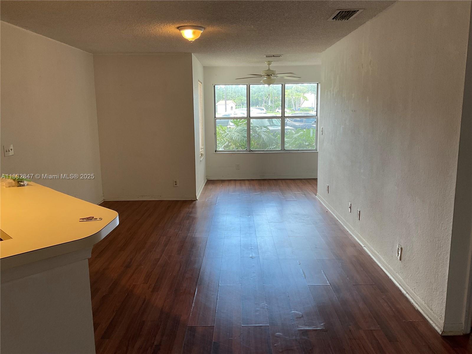 3320 Pinewalk Drive North, Unit 1715 Margate, FL 33063 - Photo 20 of 35 an empty room with wooden floor and windows