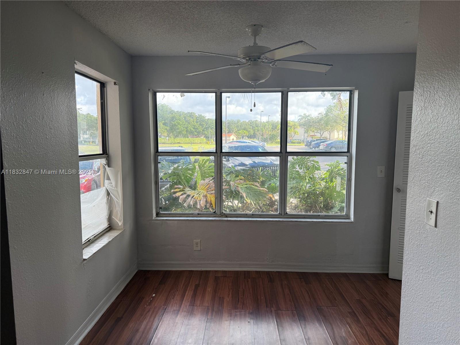 3320 Pinewalk Drive North, Unit 1715 Margate, FL 33063 - Photo 30 of 35 an empty room with wooden floor and windows