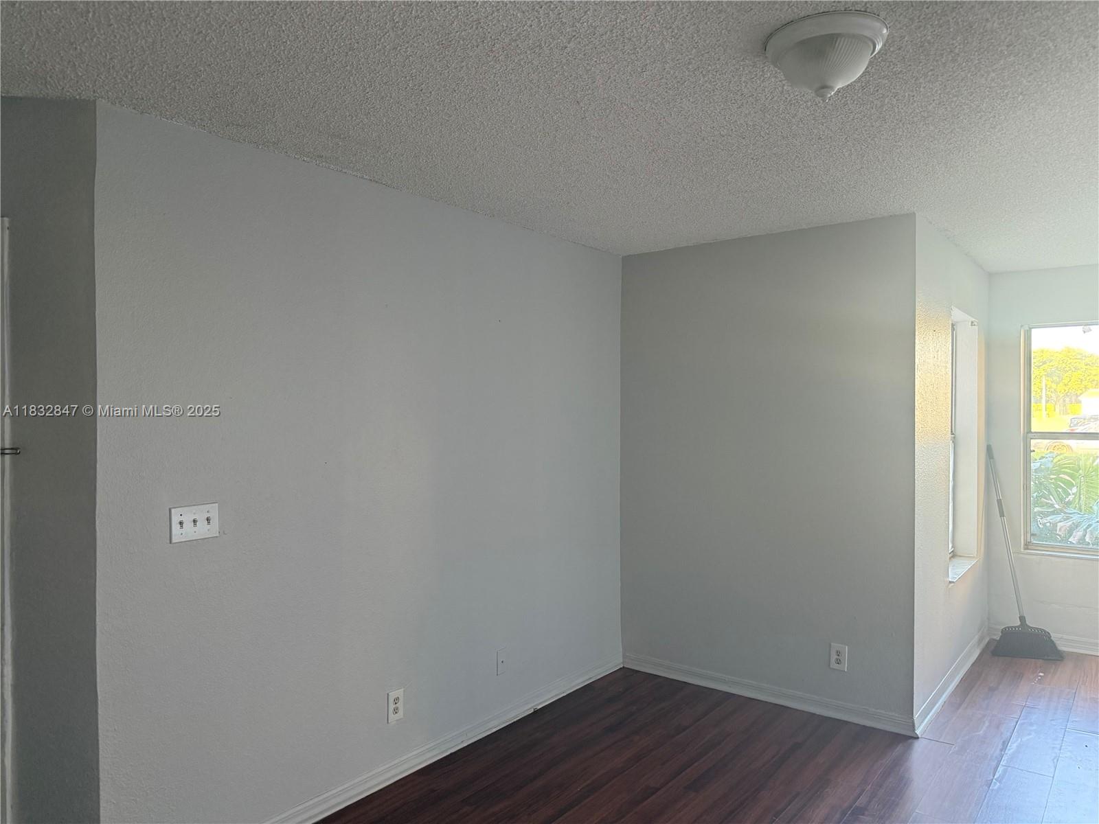 3320 Pinewalk Drive North, Unit 1715 Margate, FL 33063 - Photo 10 of 35 a view of an empty room with wooden floor and a window
