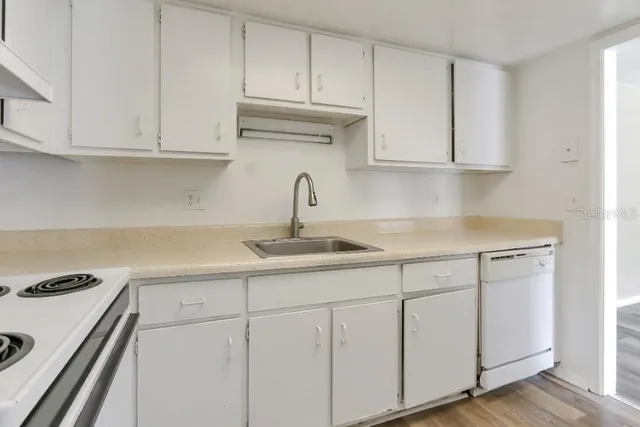 a kitchen with white cabinets and white appliances