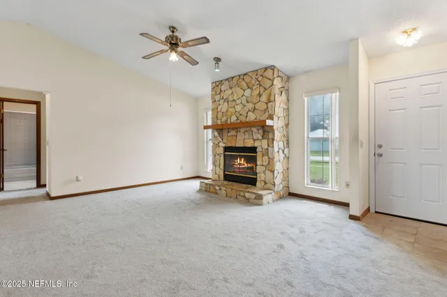 an empty room with windows and ceiling fan